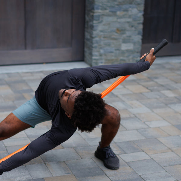 Man displaying flexibility with Stick Mobility training stick